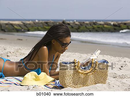 Profile of a young woman reading on the beach View Large Photo Image Stock Image - Profile of a young woman reading on the beach. Fotosearch
