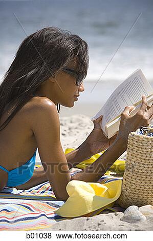 Profile of a young woman reading on the beach View Large Photo Image Stock Photo - Profile of a young woman reading on the beach. Fotosearch