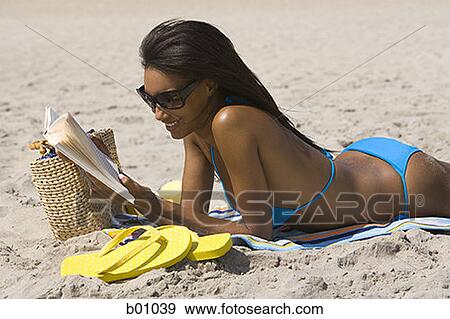 Profile of a young woman reading on the beach View Large Photo Image Stock Photo - Profile of a young woman reading on the beach. Fotosearch