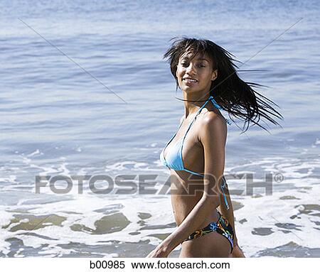 Profile of a young woman standing in water on the beach View Large Photo Image Stock Photography - Profile of a young woman standing in water on the beach. Fotosearch