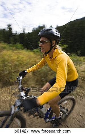 Profile of an adult woman cycling in a forest View Large Photo Image Stock Photo - Profile of an adult woman cycling in a forest. Fotosearch