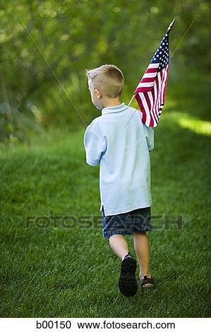 Rear view of a boy holding an American Flag View Large Photo Image Stock Image - Rear view of a boy holding an American Flag. Fotosearch