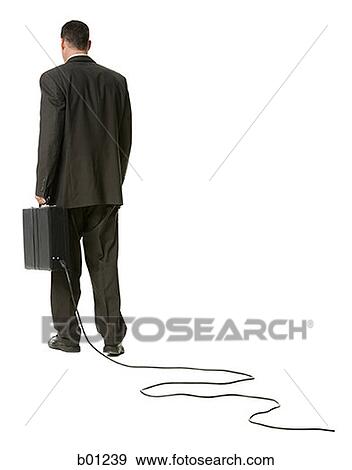 Rear view of a businessman holding a briefcase with an electrical cord View Large Photo Image Stock Photo - Rear view of a businessman holding a briefcase with an electrical cord. Fotosearch