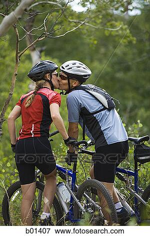 Stock Photo - Rear view of a couple mountain biking. Fotosearch