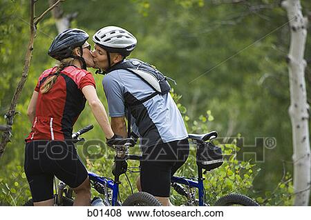 Rear view of a couple mountain biking View Large Photo Image Stock Photo - Rear view of a couple mountain biking. Fotosearch