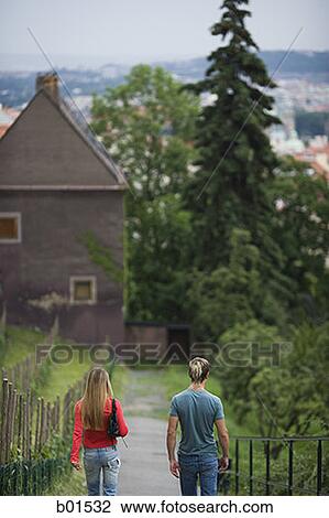 Rear view of a teenage couple walking on a path View Large Photo Image Stock Image - Rear view of a teenage couple walking on a path. Fotosearch