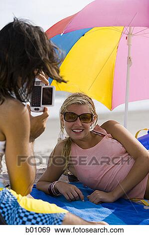 Rear view of a young man taking a young woman's photograph View Large Photo Image Stock Photo - Rear view of a young man taking a young woman's photograph. Fotosearch