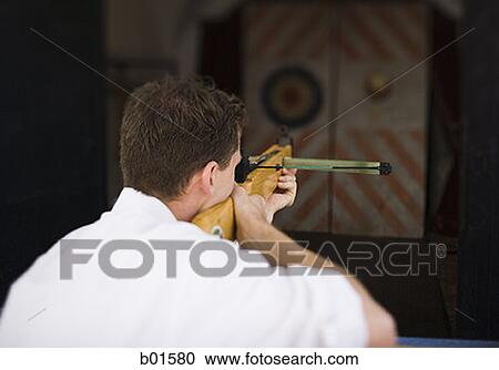 Rear view of a young man target shooting View Large Photo Image Stock Image - Rear view of a young man target shooting. Fotosearch