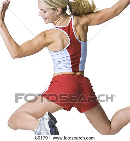 Stock Image - Rear view of a young woman jumping. Fotosearch