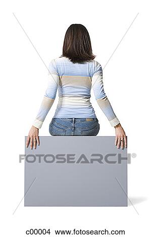 Rear view of a young woman sitting on a blank sign View Large Photo Image Picture - Rear view of a young woman sitting on a blank sign. Fotosearch