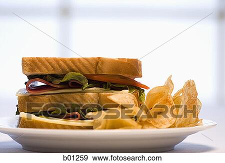 Sandwich and potato chips on a plate View Large Photo Image Stock Photo - Sandwich and potato chips on a plate. Fotosearch
