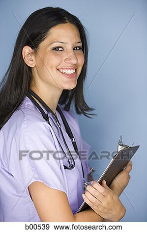 Side profile of a female nurse holding a clipboard View Large Photo Image Stock Photo - Side profile of a female nurse holding a clipboard. Fotosearch
