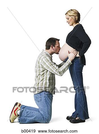 Side profile of a mid adult man kissing his pregnant wife's abdomen View Large Photo Image Stock Photo - Side profile of a mid adult man kissing his pregnant wife's abdomen. Fotosearch
