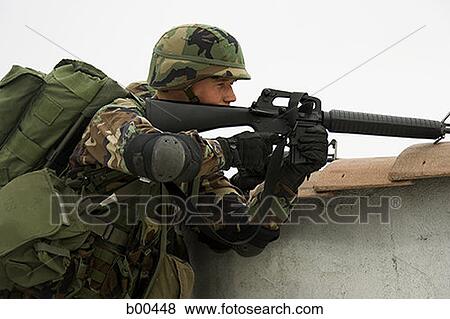 Side profile of a soldier aiming his rifle View Large Photo Image Stock Photo - Side profile of a soldier aiming his rifle. Fotosearch