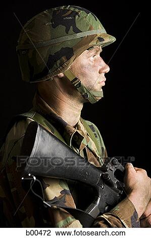 Side profile of a soldier holding a rifle View Large Photo Image Stock Image - Side profile of a soldier holding a rifle. Fotosearch