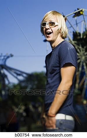 Side profile of a young man laughing in an amusement park View Large Photo Image Picture - Side profile of a young man laughing in an amusement park. Fotosearch