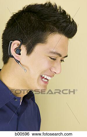 Side profile of a young man wearing a headset View Large Photo Image Stock Photograph - Side profile of a young man wearing a headset. Fotosearch