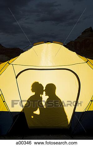 Stock Photograph - Silhouette of a couple sitting inside a tent. Fotosearch