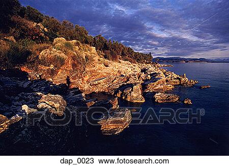 Stock Image - Storm clouds over a coastline landscape. Fotosearch