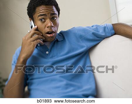 Teenage boy on a mobile phone with his mouth open View Large Photo Image Stock Image - Teenage boy on a mobile phone with his mouth open. Fotosearch