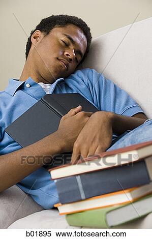 Teenage boy sleeping with a book on his chest View Large Photo Image Stock Photography - Teenage boy sleeping with a book on his chest. Fotosearch