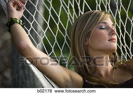 Teenage girl resting on a hammock View Large Photo Image Stock Photo - Teenage girl resting on a hammock. Fotosearch
