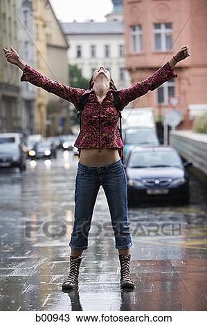 Teenage girl standing on a wet street and looking up View Large Photo Image Stock Image - Teenage girl standing on a wet street and looking up. Fotosearch