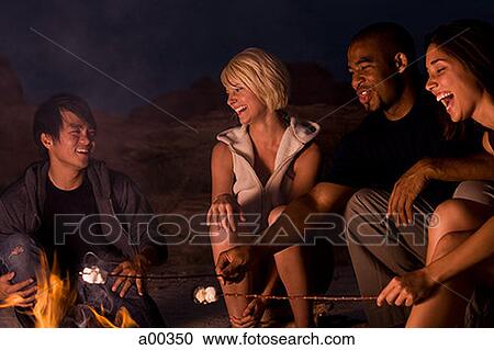Two couples sitting by a campfire View Large Photo Image Stock Image - Two couples sitting by a campfire. Fotosearch