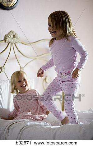 Two girls playing on the bed View Large Photo Image Stock Image - Two girls playing on the bed. Fotosearch