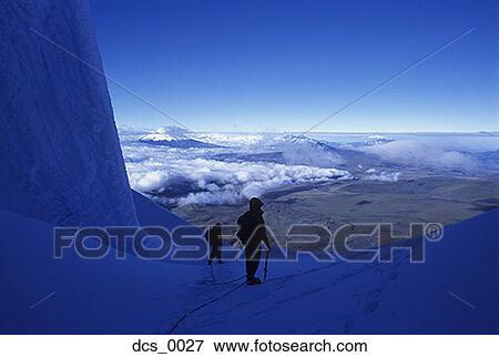 Stock Photo - Two people trekking on a snow covered mountain. Fotosearch
