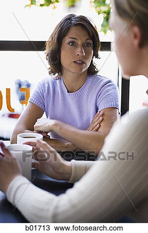 Stock Image - Two women talking over a cup of coffee. Fotosearch