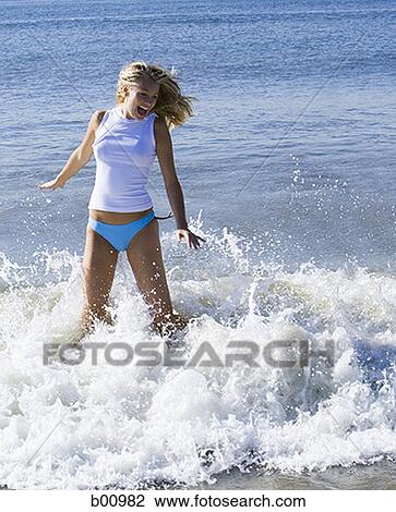 Two young women wading in the water on the beach View Large Photo Image Stock Image - Two young women wading in the water on the beach. Fotosearch