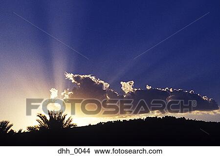 Picture - View of a sunset fading dropping behind a hill. Fotosearch
