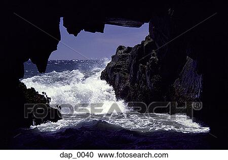 Waves crashing into an opening in rocks on the shore View Large Photo Image Stock Image - Waves crashing into an opening in rocks on the shore. Fotosearch