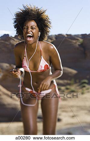 Young African-American woman listening to music View Large Photo Image Stock Image - Young African-American woman listening to music. Fotosearch