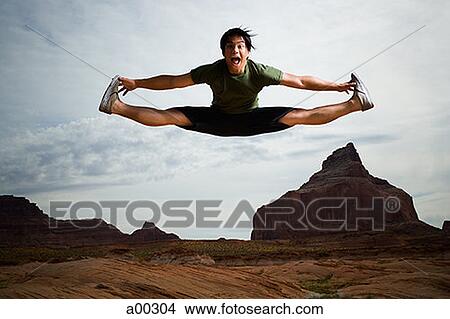 Young Asian man doing a split in mid-air View Large Photo Image Picture - Young Asian man doing a split in mid-air. Fotosearch
