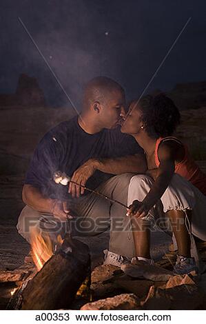 Young couple kissing by a campfire View Large Photo Image Stock Image - Young couple kissing by a campfire. Fotosearch
