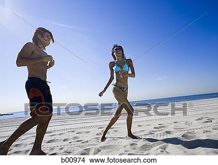 Picture - Young couple running on the beach. Fotosearch