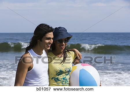Stock Photo - Young couple walking on the beach. Fotosearch