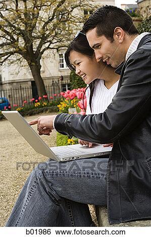 Stock Photograph - Young couple working on a laptop. Fotosearch