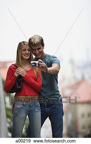 Young man and a young woman taking a photograph of themselves View Large Photo Image Stock Photo - Young man and a young woman taking a photograph of themselves. Fotosearch