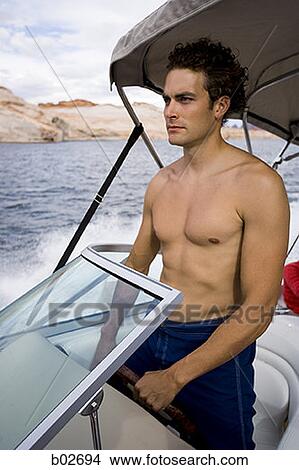 Young man driving a speed boat View Large Photo Image Picture - Young man driving a speed boat. Fotosearch