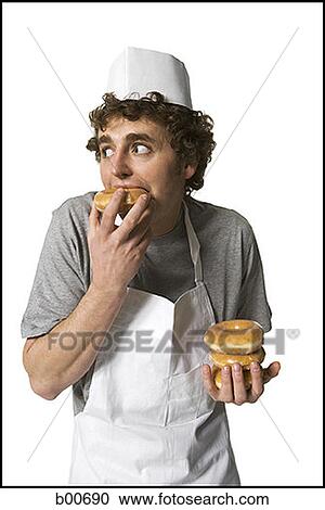 Young man eating donut View Large Photo Image Stock Image - Young man eating donut. Fotosearch