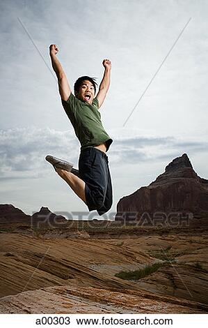 Stock Image - Young man jumping outdoors. Fotosearch