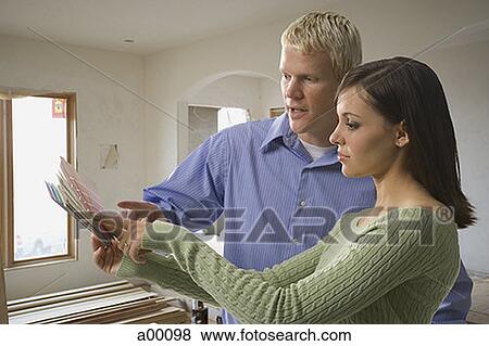 Young white couple looking at a paint color swatch View Large Photo Image Stock Photo - Young white couple looking at a paint color swatch. Fotosearch
