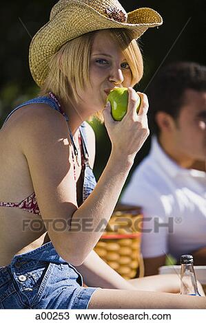 Stock Image - Young woman eating an apple. Fotosearch