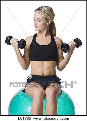 Young woman exercising with dumbbells View Large Photo Image Stock Photography - Young woman exercising with dumbbells. Fotosearch