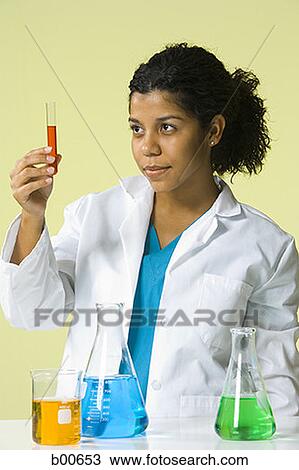 Young woman holding a test tube View Large Photo Image Stock Image - Young woman holding a test tube. Fotosearch