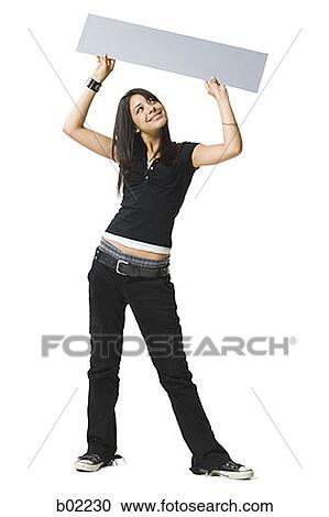 Young woman holding up a blank sign View Large Photo Image Stock Image - Young woman holding up a blank sign. Fotosearch