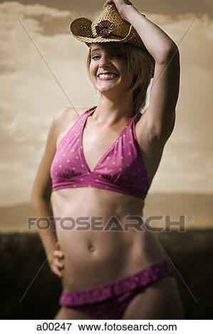 Stock Photo - Young woman in a bikini wearing a straw hat. Fotosearch